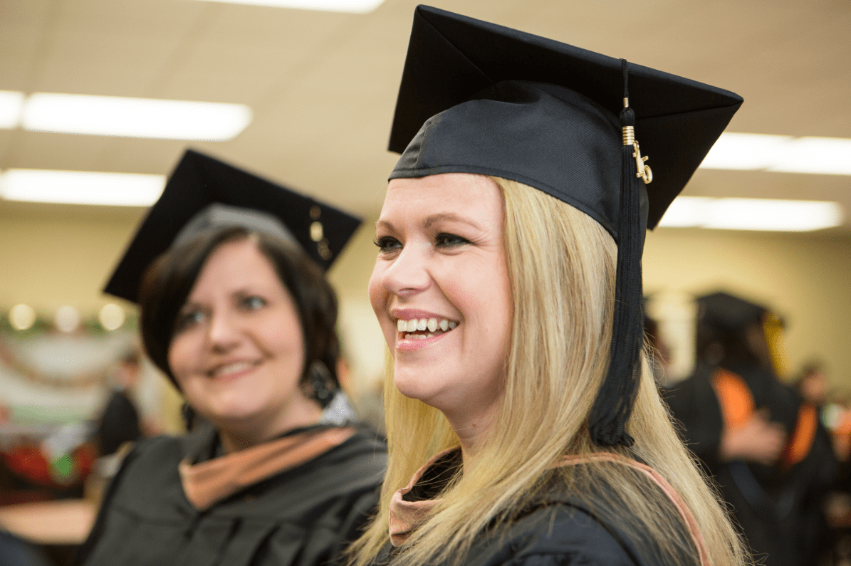 Blonde haired woman in graduation attire smiling