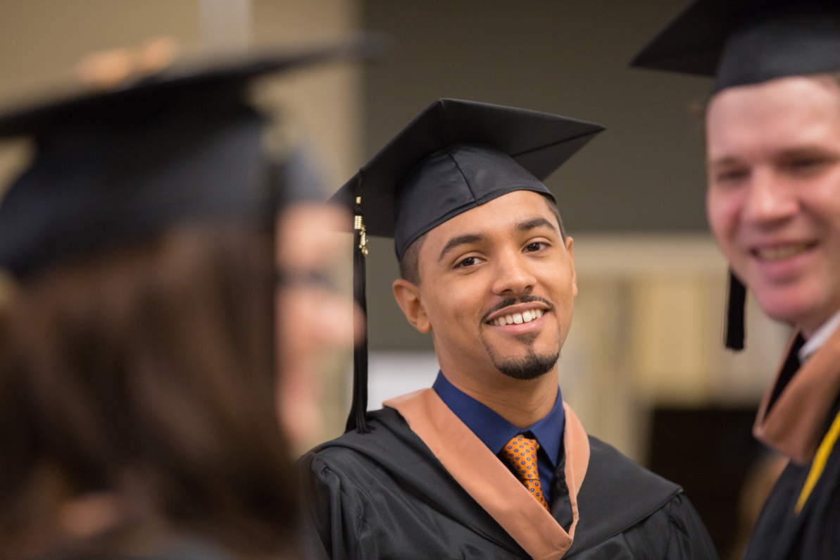 Young man in graduation attire smiling