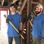 Two people in blue shirts holding tools